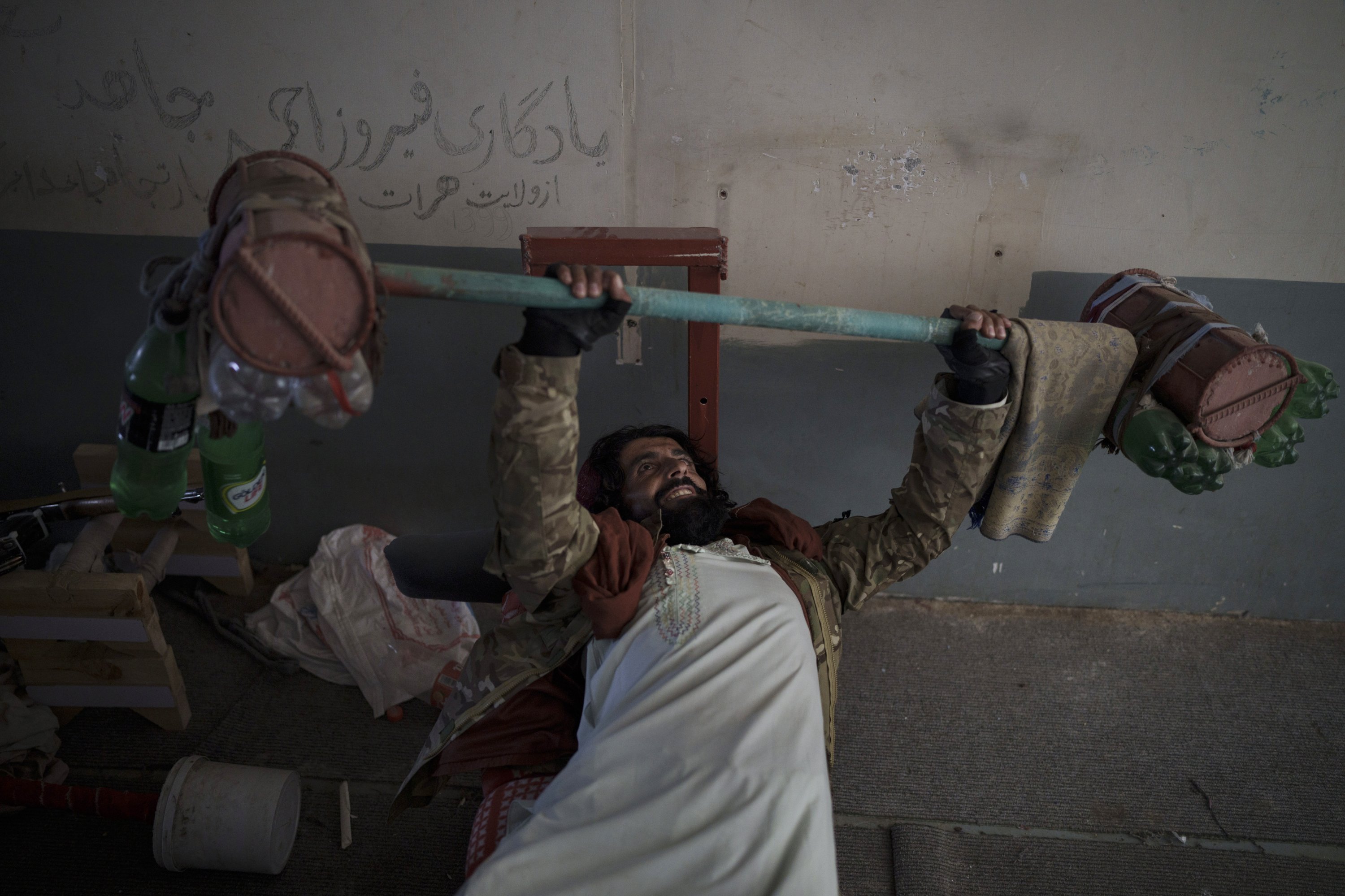 A Taliban fighter lifts a makeshift weight left behind by former prisoners at an empty area of the Pul-e-Charkhi prison in Kabul, Afghanistan, Sept. 13, 2021. (AP Photo)