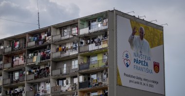 People look out from a Roma settlement at Lunik IX district with a large billboard showing an image of Pope Francis, Kosice, Slovakia, Sept. 13, 2021. (EPA Photo)