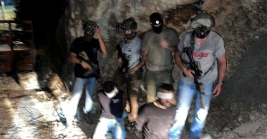 Israeli security forces stand next to Palestinians Zakaria Zubeidi and Mahmoud al-Arda after they had been arrested following their escape from Gilboa prison together with other four Palestinians, in the Israeli village of Umm Al Ghanam, Israel, September 11, 2021. (Reuters Photo)
