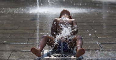 A child plays under a fountain on a hot summer day in central Brussels, Belgium, July 2, 2015. (Reuters File Photo)