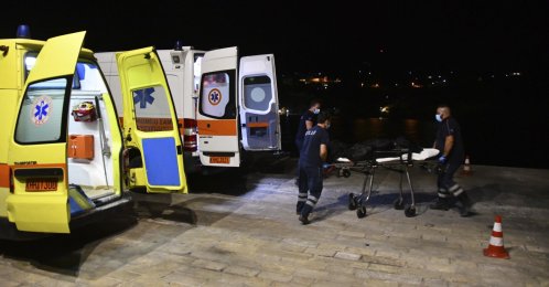 Paramedics wheel a gurney with a body at Pythagorio port, on the eastern Aegean island of Samos, Greece, Sept. 13, 2021. (AP Photo)