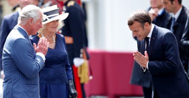 Prince Charles, Prince of Wales, accompanied by Camilla, Duchess of Cornwall, and French President Emmanuel Macron make namaste hand gestures as they say goodbye after attending a ceremony in Carlton Gardens, London, U.K., June 18, 2020. (Photo by Getty Images)