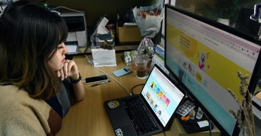 Jane Peh, co-founder of the Woof Agency which specializes in connecting pets with different brands, working at a computer in her office in Singapore, July 16, 2021. (Roslan Rahman / AFP Photo)