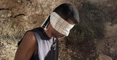 Zakaria Zubeidi, one of the six Palestinians who escaped from a high-security prison earlier this week, is blindfolded and handcuffed after being recaptured in the town of Umm al-Ghanam, northern Israel, Sept. 11, 2021. (Israeli Police via AP, File)