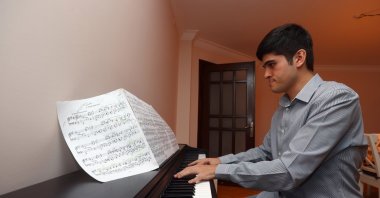 Buğra Çankır plays piano at home, in the capital Ankara, Turkey, Sept. 16, 2021. (AA PHOTO) 