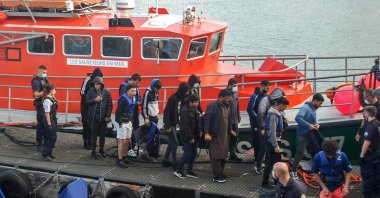 Iraqi, Iranian and Afghan migrants, with two minors among their number, disembark from a vessel after being rescued as their inflatable boat was filling with water on the English Channel, in Calais, northern France on Sept. 15, 2021. (AFP Photo)