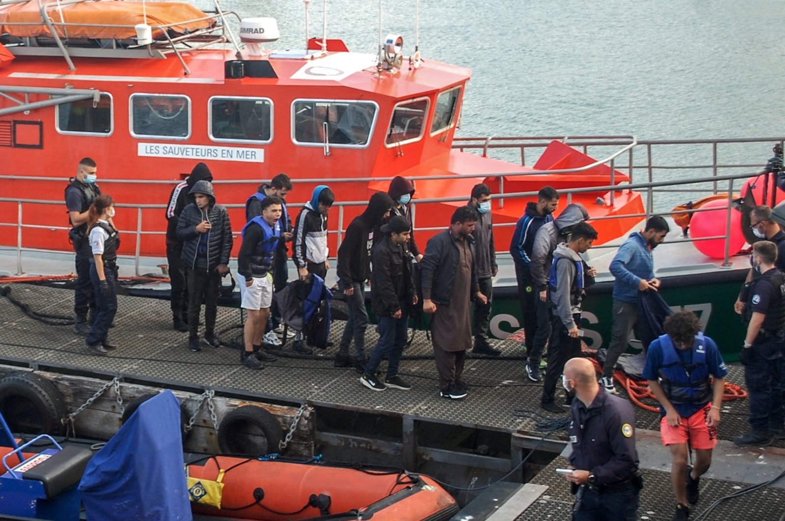 Iraqi, Iranian and Afghan migrants, with two minors among their number, disembark from a vessel after being rescued as their inflatable boat was filling with water on the English Channel, in Calais, northern France on Sept. 15, 2021. (AFP Photo)