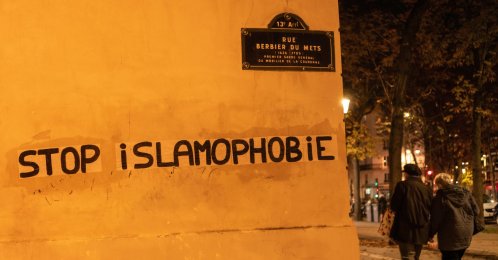People walk past graffiti that reads "Stop Islamophobia," in Paris, France, Oct. 26, 2020. (Getty Images)