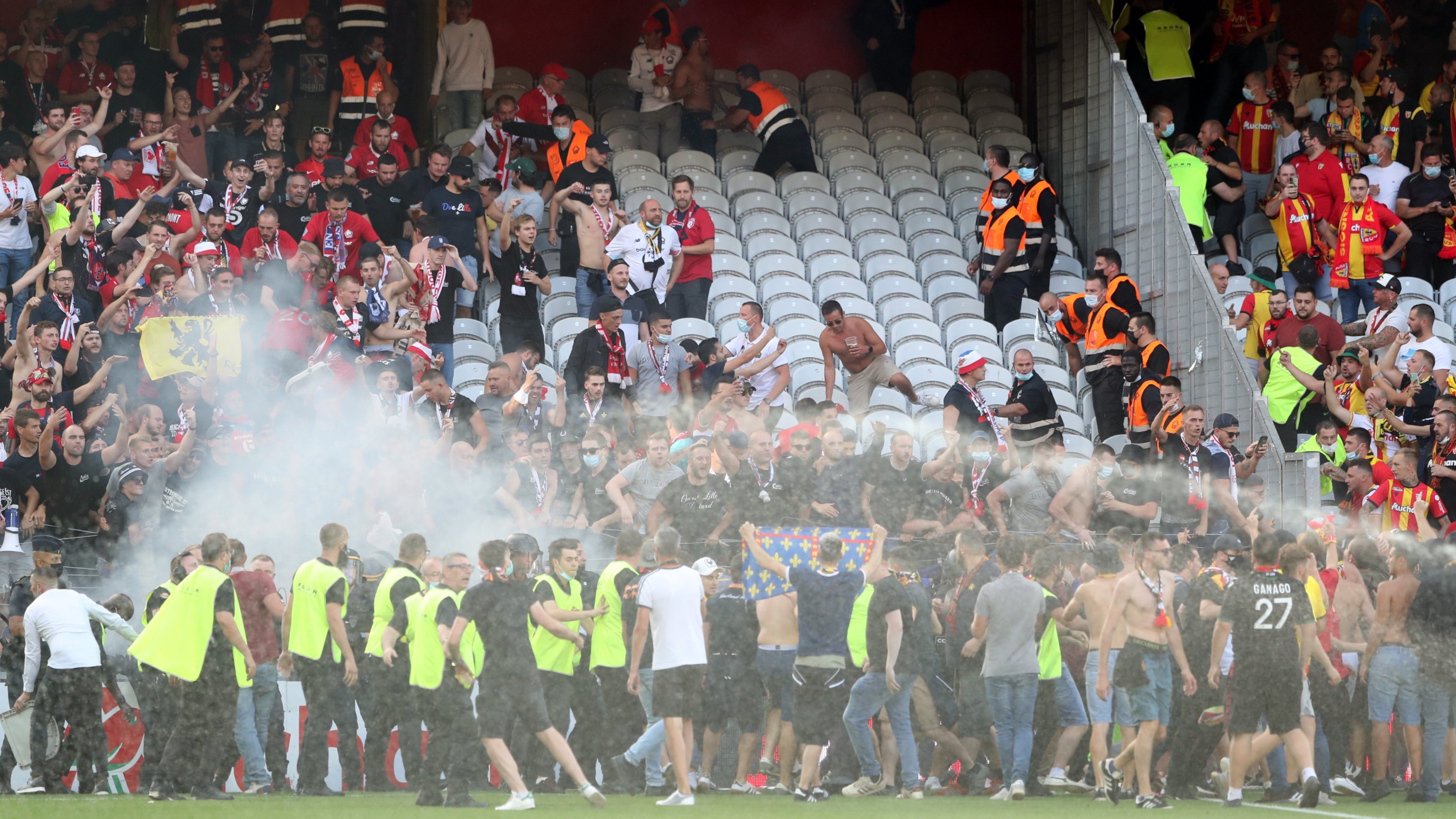Police and stewards intervene as Lens supporters invade the pitch during the French Ligue 1 match against Lille at the Stade Bollaert-Delelis in Lens, France, Sept. 18, 2021. (Reuters Photo)