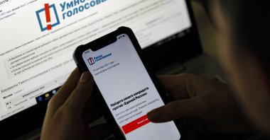 A woman examines Navalny's Smart Voting app on her cellphone in Moscow, Russia, Sept. 17, 2021. (EPA Photo)