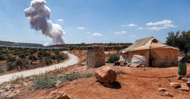 A plume of smoke rises after an aerial bombardment near a make-shift camp for displaced Syrians near the town of Kafraya in the north of Syria's rebel-held Idlib province, Sept. 7, 2021. (Photo by OMAR HAJ KADOUR / AFP)