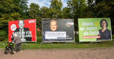 An elderly woman walks past large election placards of the three leading candidates in the German federal elections (L-R) Olaf Scholz of the Social Democratic Party (SPD), Armin Laschet of the Christian Democratic Union (CDU) and Annalena Baerbock of the Green Party (Buendnis 90/Die Gruenen) in Frankfurt am Main, Germany, Sept. 17, 2021. (EPA Photo)