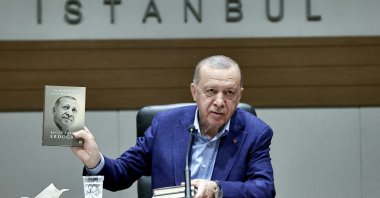 President Recep Tayyip Erdoğan holds his book "A Fairer World Is Possible" while addressing reporters ahead of his visit to the United States, Istanbul, Turkey, Sept. 19, 2021. (AA Photo)