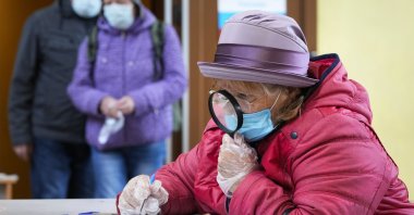 A woman fills her ballots during the State Duma, the Lower House of the Russian Parliament and local parliaments elections at a polling station in Saint Petersburg, Russia, Sept. 17, 2021. (AP Photo)
