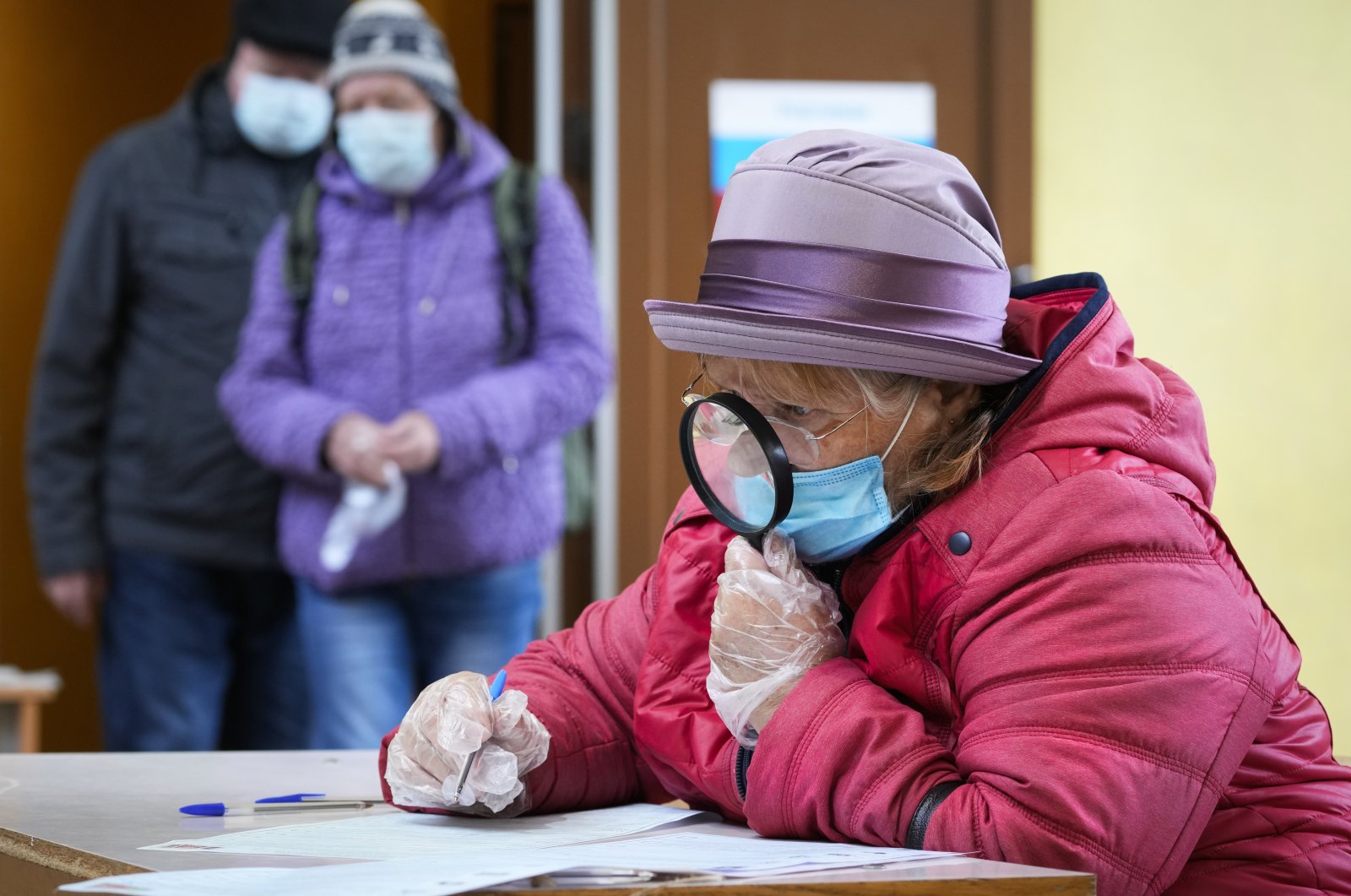 A woman fills her ballots during the State Duma, the Lower House of the Russian Parliament and local parliaments elections at a polling station in Saint Petersburg, Russia, Sept. 17, 2021. (AP Photo)