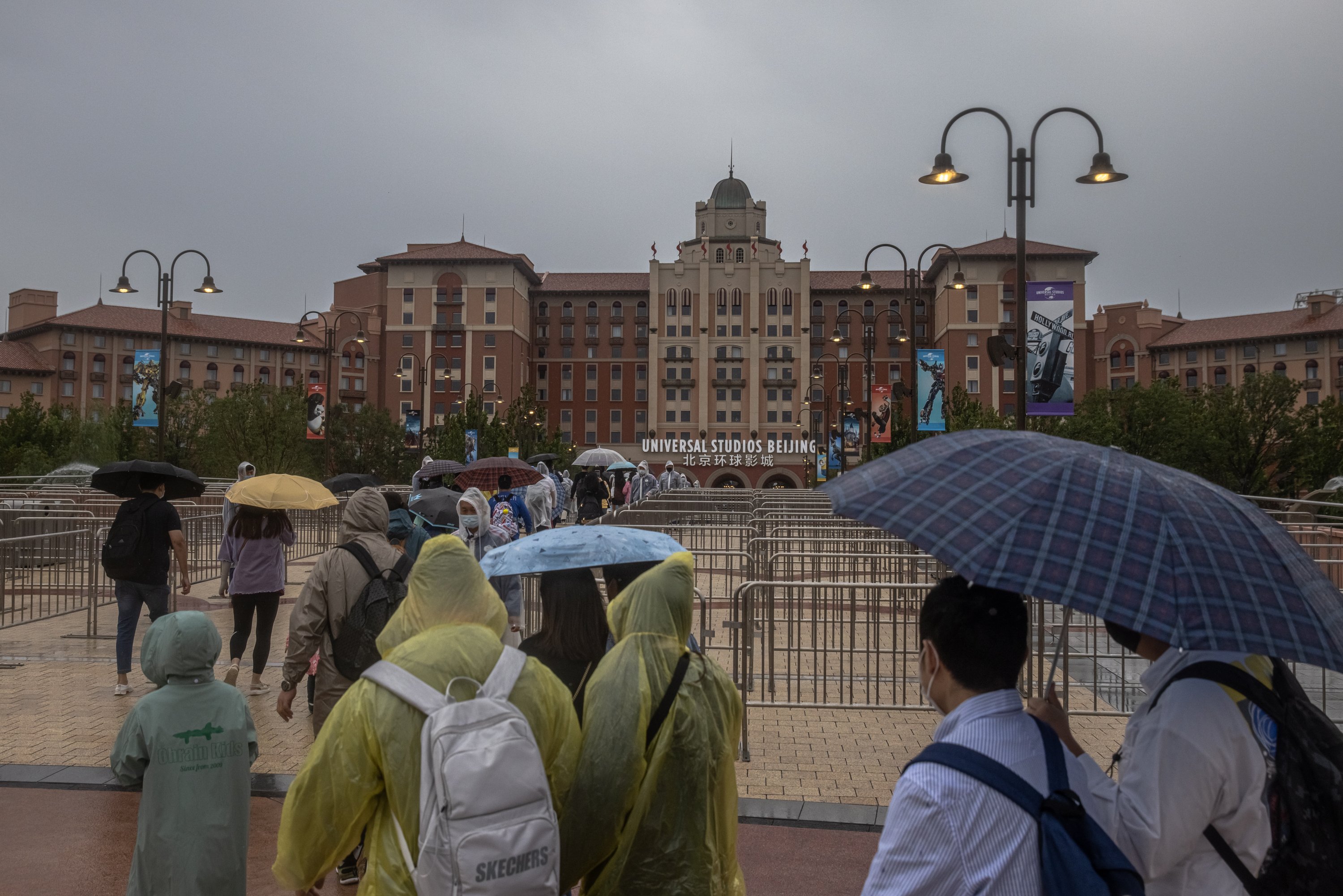 Visitors walk under the rain to enter Universal Studios Beijing on the official opening day, in Beijing, China, Sept. 20, 2021. (EPA Photo)