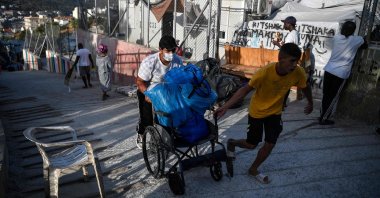 Men carry belongings on a cart at the old Vathy camp, on the island of Samos before being transferred to the new Samos RIC, the first of five new "closed" migrant camps, Greece, Sept. 20, 2021 (AFP Photo)