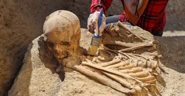 A close-up of an archaeologist's hand while working on one of the newly found graves around Çavuştepe Castle, Van, eastern Turkey, Sept. 19, 2021. (AA Photo)