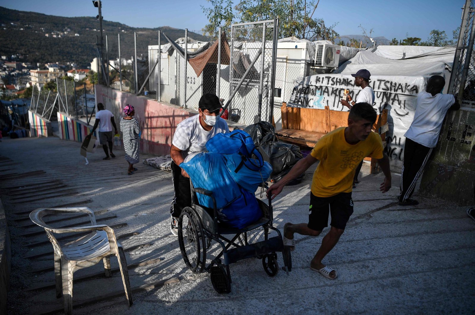 Men carry belongings on a cart at the old Vathy camp, on the island of Samos before being transferred to the new Samos RIC, the first of five new "closed" migrant camps, Greece, Sept. 20, 2021 (AFP Photo)