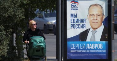 A woman walks past a campaign poster of Russian Foreign Minister Sergei Lavrov of the United Russia political party ahead of the Russian parliamentary and regional voting in Simferopol, Crimea, Sept. 15, 2021. (Alexey Pavlishak via Reuters)