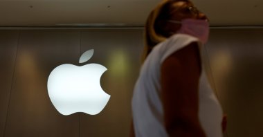 A woman walks past an Apple logo in front of an Apple store in Saint-Herblain near Nantes, France, Sept. 16, 2021.  (Reuters Photo)
