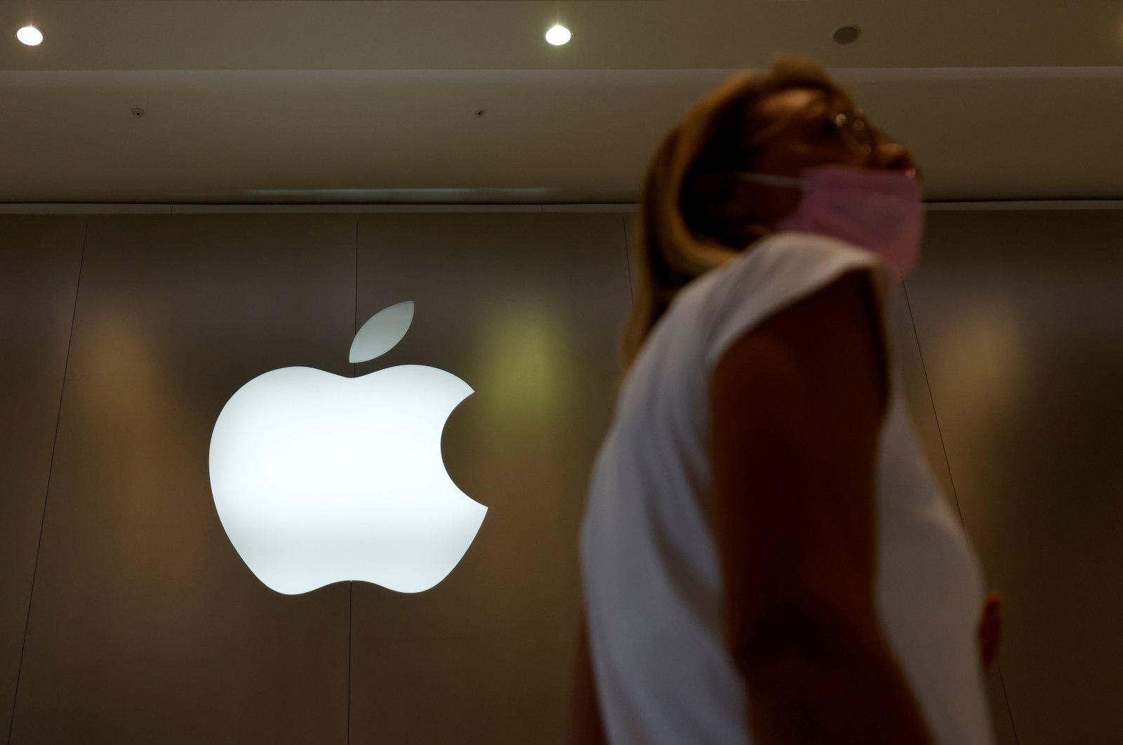 A woman walks past an Apple logo in front of an Apple store in Saint-Herblain near Nantes, France, Sept. 16, 2021.  (Reuters Photo)