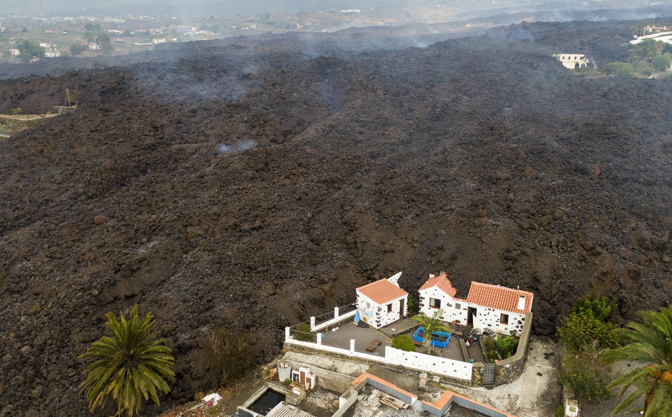 Lava from a volcano eruption flows destroying houses on the island of La Palma in the Canaries, Spain, Sept. 21, 2021. (AP Photo)