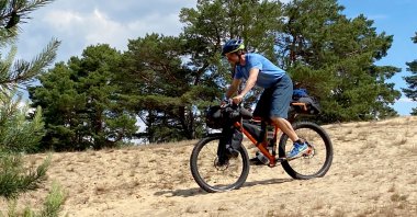 Thanks to its wide tread tires, this bikepacking bike – similar to a mountain bike – masters difficult terrain like this sandhill far better than a trekking bike with narrower tires. (DPA Photo)