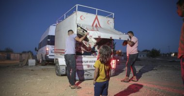 Members of a seasonal laborer family empty a truck where they loaded their possessions, in Şanlıurfa, southeastern Turkey, Sept. 21, 2021. (AA PHOTO) 
