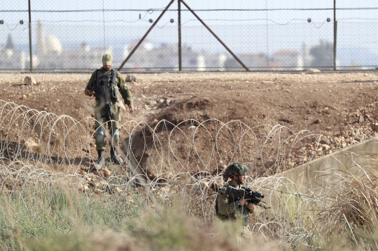 Israeli soldiers take positions along the border as they search for two Palestinians who broke out of a maximum-security prison last week, on a road leading to the West Bank town of Jenin, near Gan Ner, Israel, Sept. 12, 2021. (AP Photo)