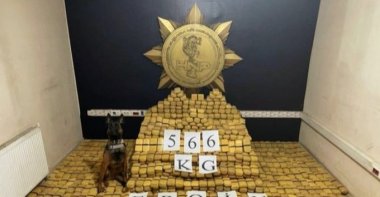 A counter-narcotics dog poses with seized heroin, in Hakkari, southeastern Turkey, Sept. 23, 2021. (AA PHOTO) 