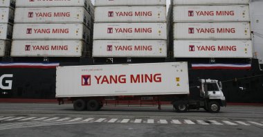 A Taiwanese shipping company loads containers on a ship in the harbor of Keelung, Taiwan, Dec. 15, 2008. (AP Photo)