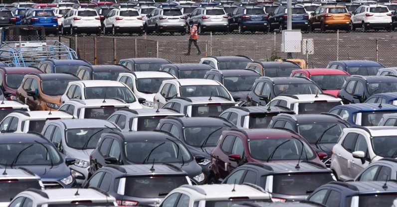 An Indian worker (back C) walks near parked Ford cars at the Ford India plant located in Chengalpattu, some 50 kilometers south of Chennai, India, Sept. 13, 2021. (EPA Photo)