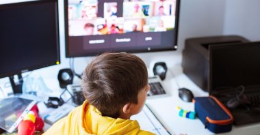 A child attends remote lessons on a computer. (Alamy Photo)