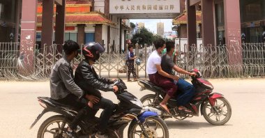 Motorists pass the China-Myanmar border gate in Muse in Shan state, as the Chinese city of Ruili near the border with Myanmar imposed a lockdown and started mass testing after three coronavirus cases were reported, July 5, 2021. (AFP Photo)