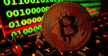 Bitcoin cryptocurrency representation is pictured on a keyboard in front of binary code in this illustration photo taken Sept. 24, 2021. (Reuters Photo)