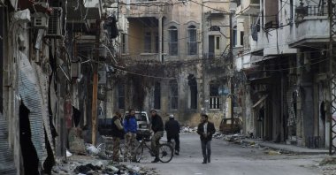 Men stand on a street lined with damaged buildings in the besieged area of Homs, Feb. 24, 2014, Syria. (Reuters Photo)