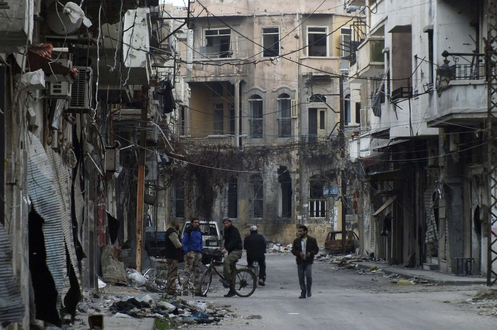 Men stand on a street lined with damaged buildings in the besieged area of Homs, Feb. 24, 2014, Syria. (Reuters Photo)