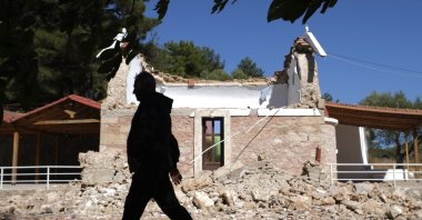 A Resident passes next to a damaged Greek Orthodox chapel after a strong earthquake in Arcalochori village on the southern island of Crete, Greece, Sept. 27, 2021. (AP Photo)
