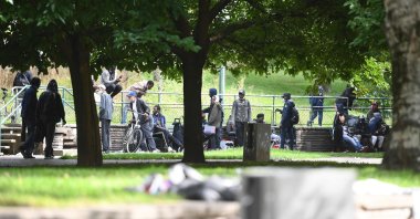 People sit on benches after being relocated near the Porte de la Villette, northern Paris, on Sept, 24, 2021. (AFP Photo)