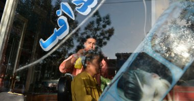 Nader Shah (L) attends a customer at his barbershop in Herat, Sept. 19, 2021. (AFP Photo)