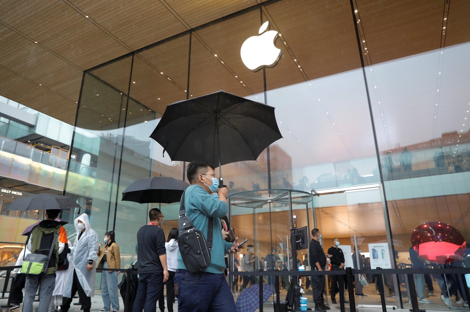 People wearing face masks are pictured at an Apple Store on the day the new Apple iPhone 13 series goes on sale, in Beijing, China, Sept. 24, 2021. (Reuters Photo)