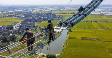 Employees working on a high-voltage direct current transmission line in Wuxi, in China's eastern Jiangsu province, Sept. 27, 2021. (Reuters Photo)