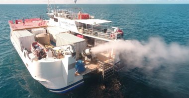 Plume from sprayer jets on a vessel is seen during the second field trial at Broadhurst Reef on the Great Barrier Reef, Queensland, Australia, March, 2021. (Southern Cross University via Reuters)