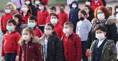 Pupils wearing protective facemasks stand in the courtyard of a school in Ankara on March 2, 2021, after the country lifted restriction measures against the COVID-19 pandemic in regions with lower infection rates. (AFP Photo)