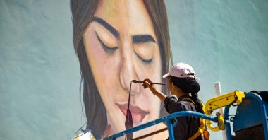 Moroccan street artist Imane Droby works on a mural during the Jidar street art festival in the capital Rabat, Morocco, Sept. 20, 2021. (AFP Photo)