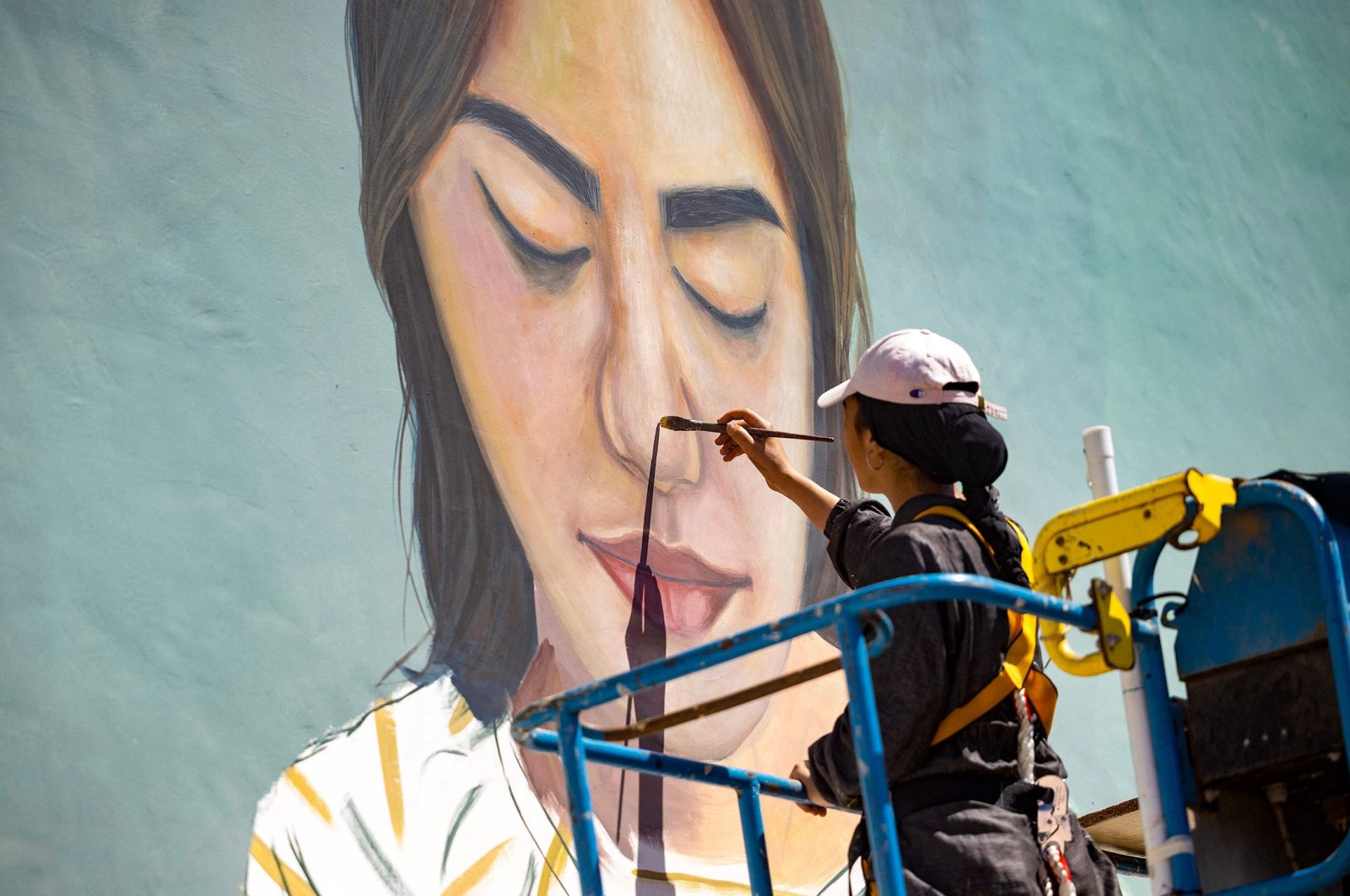Moroccan street artist Imane Droby works on a mural during the Jidar street art festival in the capital Rabat, Morocco, Sept. 20, 2021. (AFP Photo)