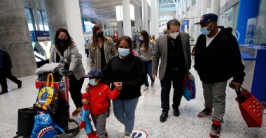 Nadeeka Dilrukshi Nonis holds the hand of her son Dinath, and Supun Thilina Kellapatha (R) speaks with lawyer Marc-Andre Seguin (2R), as they arrive in Canada as refugees at Pearson International Airport in Toronto, Ontario, Canada, Sept. 28, 2021. (AFP Photo)