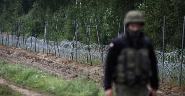 A Polish soldier walks past a barbed wire fence under construction on the border with Belarus in Zubrzyca Wielka near Bialystok, eastern Poland, Aug. 26, 2021. (AFP Photo)
