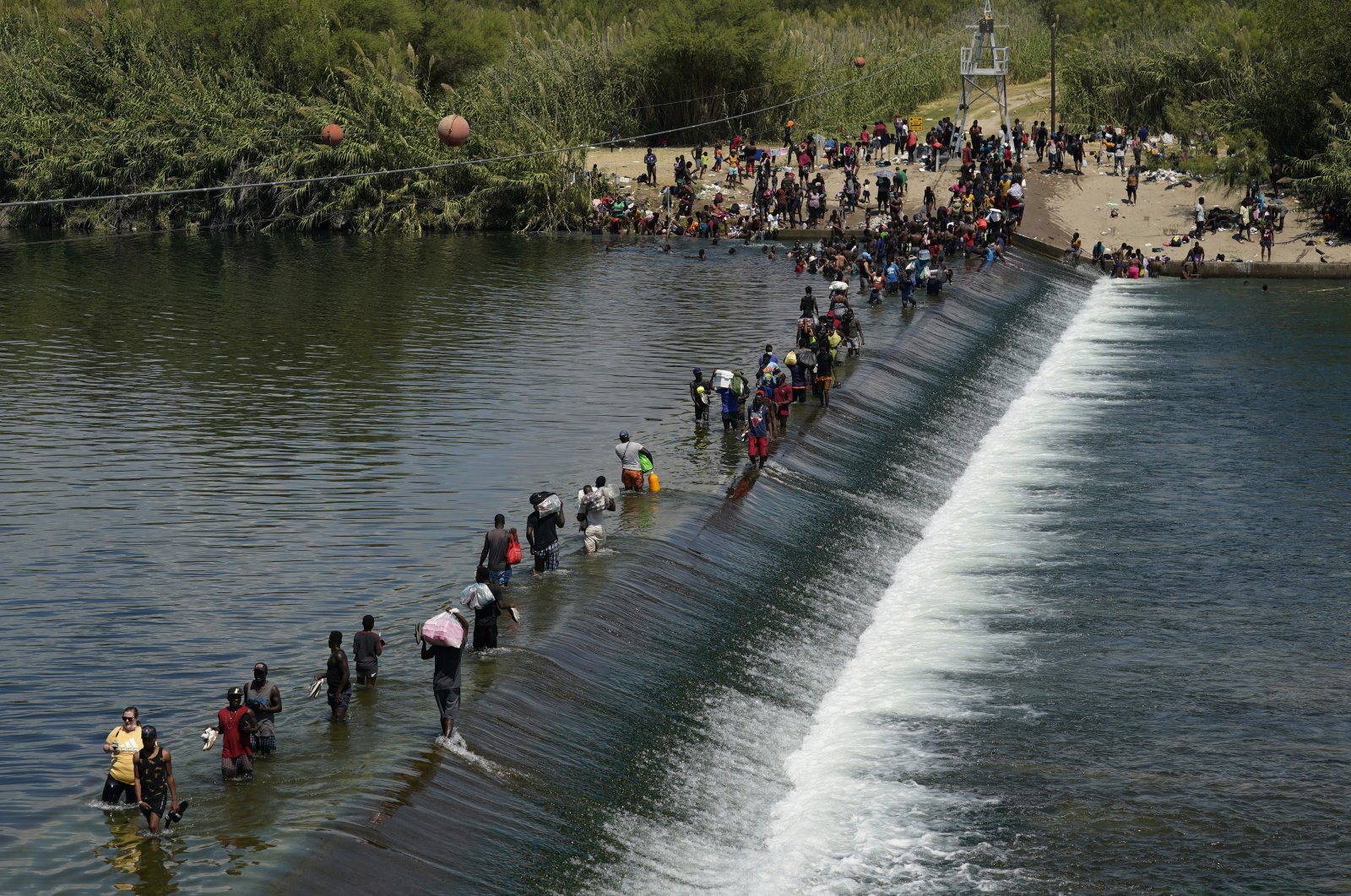 Haitian migrants use a dam to cross into the United States from Mexico in Del Rio, Texas, U.S., Sept. 18, 2021. (AP Photo)